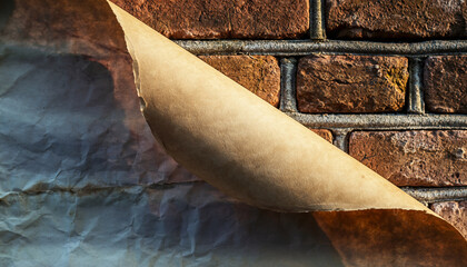 A torn piece of paper peeling away from a brick wall.