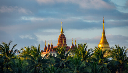 Ancient temple with multiple spires surrounded by lush palm trees.