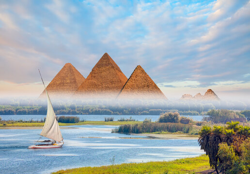 Beautiful Nile scenery with traditional Felluca sailing boat in the Nile on the way to Giza pyramids - Cairo, Egypt