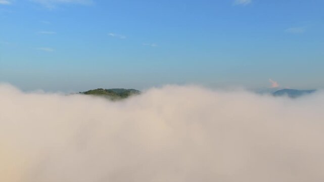 Forested Hilltops Revealed Behind Blanket Of Low Clouds On Sunny Day. El Carrizo Reservoir In Jalisco, Mexico. drone shot