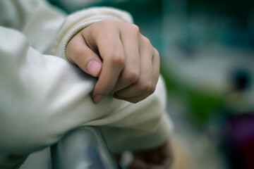 Hand resting on fence in outdoor urban setting