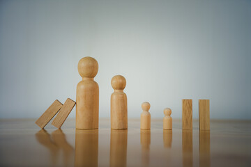 Lined up wooden pieces, one wooden piece override the wooden people pawns in business concept 
