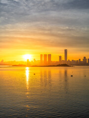 Naklejka premium Sunrise over Xiamen's coastal cityscape, Fujian Province, China