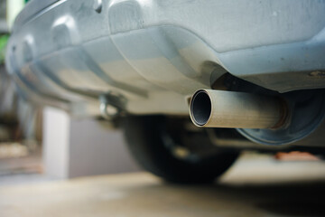 Dirty exhaust pipe of a passenger car with a diesel engine. View from below, rear. 
