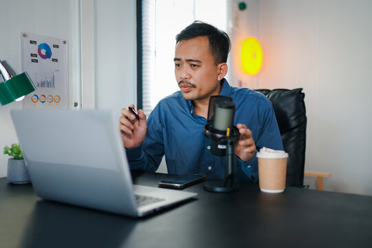 Image of radio host using microphone and laptop to recording podcast in home studio. Radio, podcasts and technology concept 
