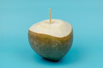 Noix de coco perc&eacute;e sur fond bleu