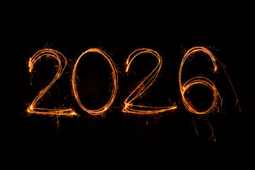 Happy New Year 2026 written sparkling sparklers isolated on black background with copy space for text.