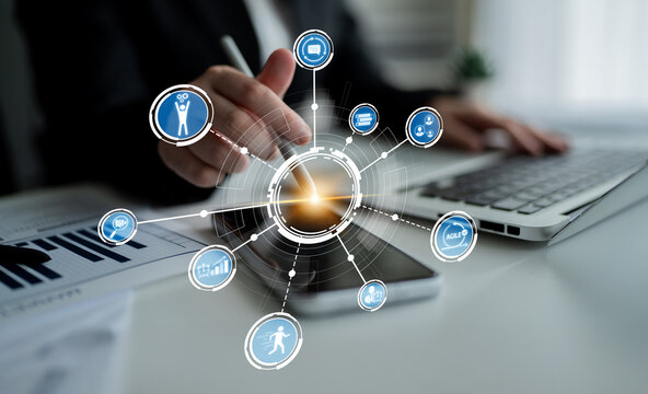 A business professional interacts with a digital interface on a smartphone and laptop, showcasing innovative technology for data visualization and analysis in a modern workspace. Crux - Powered by Adobe