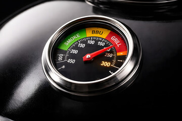 Naklejka premium Crisp close-up of glowing BBQ thermometer reading ideal heat level