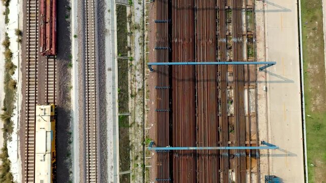 Industrial Railroad Yard with Freight Trains and Loading Cranes Aerial View