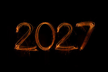 Happy New Year 2027 written sparkling sparklers isolated on black background with copy space for text.
