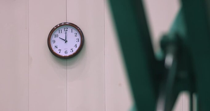 Wall Clock Showing 9 o'Clock with Blurred Figure in Office