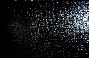 小さい四角形を並べたでこぼことした柄の模様でざらざらとして表面の質感の石の壁に光があたったようなイメージで暗い黒や灰の色のモノクロの配色でデザインした壁紙、背景、テクスチャ