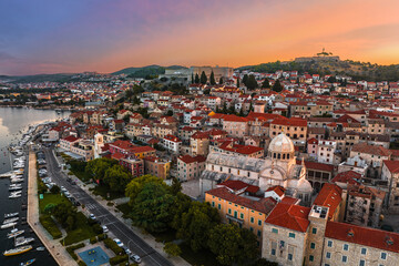 Fototapeta premium Sibenik, Croatia - Aerial view of the mediterranean old town of Sibenik on a sunny summer morning with Saint James Cathedral, Fortress of Saint Michael and dramatic golden sunrise by the Adriatic sea