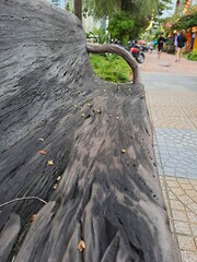 Artistic wooden seating with natural branch armrests located in a landscaped park area