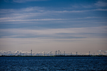 Offshore wind turbines on the horizon over blue water