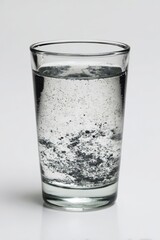 Single glass of murky water, stark contrast on plain white background