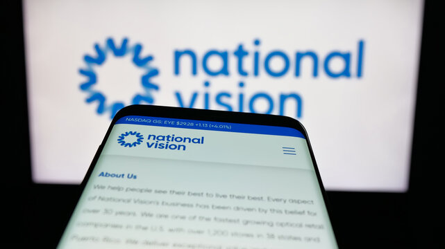 Stuttgart, Germany - 12-11-2025: Mobile phone with website of optical retail company National Vision Inc. on screen in front of logo. Focus on top-left of phone display.