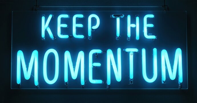 Bright neon sign displays text. Words keep momentum glow vividly against dark background. Simple, motivational message.