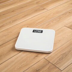 Modern white digital bathroom scale with illuminated display sits on a light wood floor