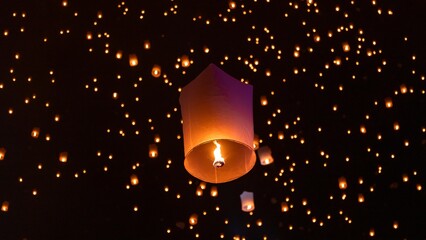 Obraz premium Sky lantern floating in the dark night sky, Tourist floating sky lanterns, Sky lanterns floating on night of Yi Peng, Loy Krathong Festival or Yi Peng Festival in Chiang Mai Thailand.