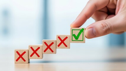 Hand placing wooden block with green checkmark over blocks with red crosses, symbolizing choice, decision making, success, or voting