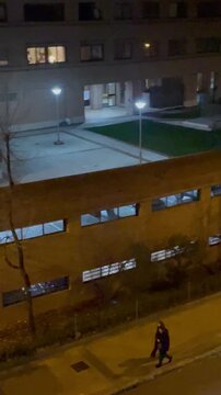 Personas caminando y coches circulando por ciudad por la noche en calle urbana de edificio alto