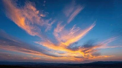Fototapeta premium Wide-angle sky at dusk with warm orange tones and blue clouds