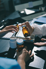 Female doctor holding a medicine bottle is checking the quality of medicine for any side effects the patient or not and recording patient information at the hospital. medical and health care concept
