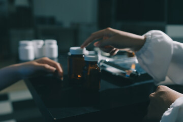 Female doctor holding a medicine bottle is checking the quality of medicine for any side effects the patient or not and recording patient information at the hospital. medical and health care concept