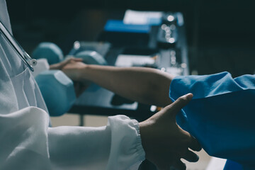 Physical therapist assisting a woman with dumbbell exercise