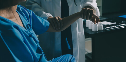 Doctor examining patient's elbow in hospital room