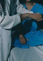 Doctor examining patient's elbow in hospital room