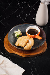 Sushi with Soy Sauce on Black Plate.