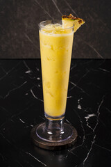 Yellow Cocktail with Orange Garnish.