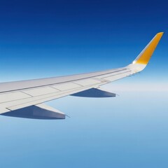 Obraz premium Airplane wing, partially in frame, extending against brilliant azure sky, above the clouds