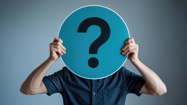 Person holding large blue question mark sign over face against plain grey background symbolizing dou