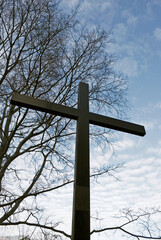 tall wooden cross and bare tree