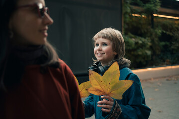 Mother and teenage daughter having fun together at walk in autumn city