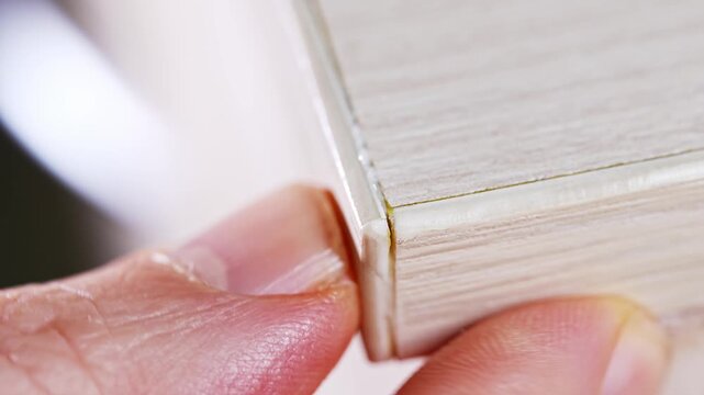the master glues the veneer edge, thin natural wood, came off the furniture. wear and tear of old furniture.