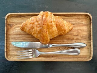 Close-up of a fresh French croissant on a wooden board