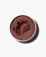 Rich deeply pigmented dark terracotta brown cream cosmetic product swatch isolated against a stark white background for beauty flat lay.