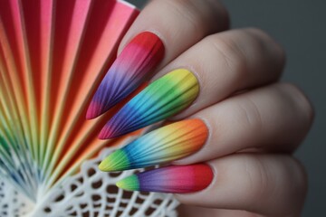Bright rainbow fan and colorful fake nails showcase vibrant design in a fun, artistic display for creative enthusiasts during a sunny afternoon
