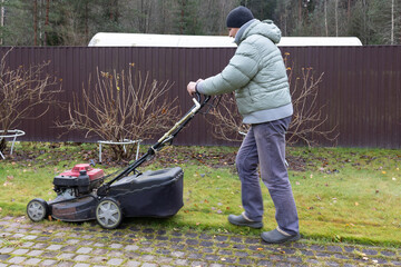 Man uses lawnmower to cut grass 