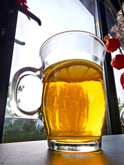 Mug of tea with lemon on the table in a cafe.