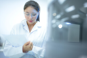 Obraz premium Female specialist calibrating an advanced automated tissue processor in a sterile pathology laboratory. Technical scientist validating high-throughput diagnostic machinery protocols.