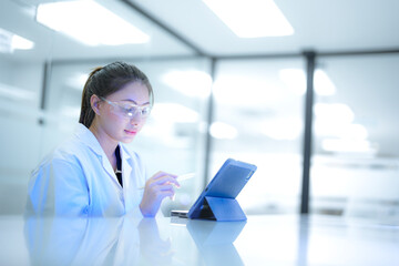 Focused female scientist using a digital tablet to analyze research data in a modern sterile...
