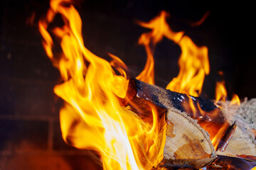 Flames rise from burning logs in a fireplace