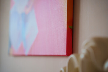 Colorful wall art hangs close to a white sculpture