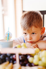 Child looks at fruit with curiosity in kitchen